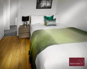 - une chambre avec un grand lit et une table de nuit dans l'établissement Yateley - Spacious 2 Bedroom House, à Finchampstead