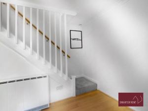 Cette chambre blanche dispose d'un escalier et d'une photo murale. dans l'établissement Bracknell - Modern, Spacious 1 Bedroom House, à Easthampstead