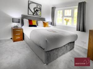 a bedroom with a large bed and a window at Bracknell - Modern, Spacious 1 Bedroom House in Easthampstead