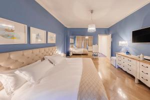 a bedroom with a large white bed and a television at Maison de Famille in Palermo