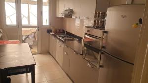 a kitchen with a refrigerator and a stove top oven at Coralia Bel F3 clim wifi parking privé Iptv in Oujda
