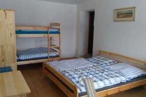 a bedroom with two bunk beds and a table at Chalupa na Vysočině in Sněžné