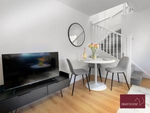 a dining room with a table and a large tv at Wokingham - 2 Bed Modern House - Parking in Wokingham