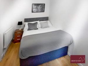 a bedroom with a large bed with white sheets at Wokingham - 2 Bed Modern House - Parking in Wokingham