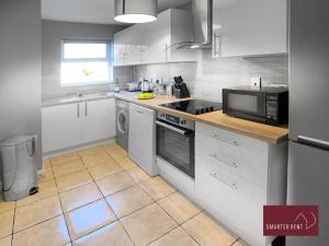 een keuken met een wastafel en een fornuis top oven bij Knaphill - 2 Bedroom House - With Parking in Brookwood