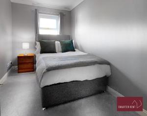 een kleine slaapkamer met een bed en een raam bij Knaphill - 2 Bedroom House - With Parking in Brookwood
