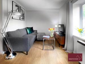 uma sala de estar com um sofá cinzento e uma mesa em Wokingham - 2 Bedroom House em Wokingham