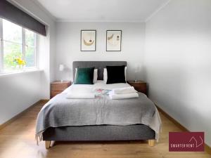 a bedroom with a large bed with two pillows at Wokingham - 2 Bedroom House in Wokingham