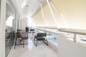 a large room with chairs and tables and windows at The Urban Utopia at Glyfada in Athens