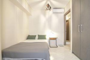 um quarto com uma cama num quarto branco em The Urban Utopia at Glyfada em Atenas