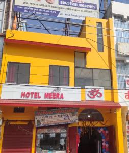 HOTEL MEERA في Bettiah: مبنى اصفر عليه علامة مكه للفندق