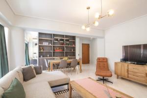 a living room with a couch and a dining room at The Urban Utopia at Glyfada in Athens