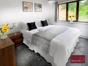 um quarto com uma grande cama branca e uma janela em Hitchin - Millstream - 2 Bedroom Coach House em Ickleford