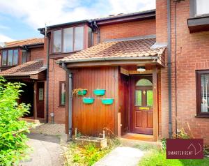 a house with three green bowls on the door at Hitchin - Millstream - 2 Bedroom Coach House in Ickleford