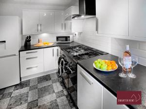 uma cozinha com armários brancos e uma taça de fruta no balcão em Farnborough - Peel Court - 2 Bed Parking & Garden em Cove