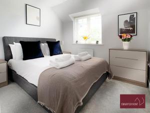 a bedroom with a large bed with towels on it at Wokingham - 2 bed House with garden in Wokingham