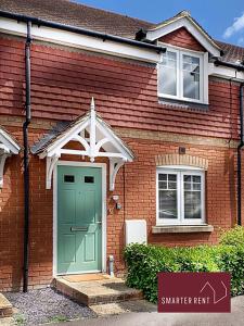 a red brick house with a green door at Wokingham - 2 bed House with garden in Wokingham