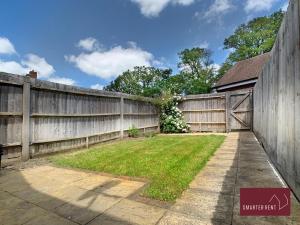 una valla con una puerta de madera y un patio en Wokingham - 2 bed House with garden, en Wokingham