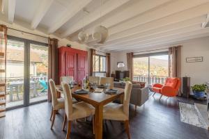 comedor con mesa, sillas y sofá en La Villa suspendue, Jolie terrasse vue lac au calme - LLA Selections by Location lac Annecy, en Saint-Jorioz