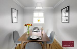 a dining room with a wooden table and chairs at Wokingham - 2 Bedroom Ground Floor Flat - With Parking in Wokingham
