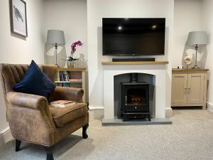 a living room with a fireplace with a television above it at The Sail Loft in Cowes