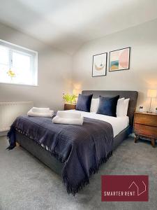 um quarto com uma cama grande e almofadas azuis em Ascot - Immaculate 2 bed House with parking em Ascot