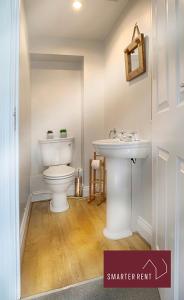 a bathroom with a white toilet and a sink at Ascot - Parking Garden Pets Welcome in Ascot