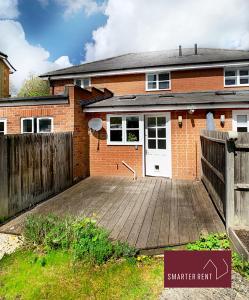 a brick house with a wooden deck in front of it at Ascot - Immaculate 2 bed House with parking in Ascot
