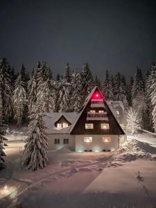 a house in the snow with a red light at Berghaus in Kurort Bärenburg