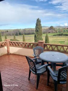 una mesa y sillas en un patio con vistas en Agriturismo La Verde Rosa, en Pescia Romana