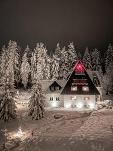 a barn with a red light on it in the snow at Berghaus in Kurort Bärenburg