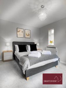 um quarto com uma cama grande e um lustre em Lightwater - Immaculate 1 Bedroom House em Bagshot