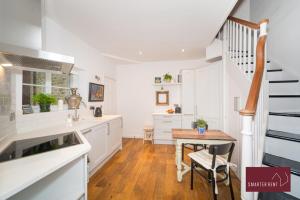 a kitchen with white cabinets and a wooden table at The Gazebo in London