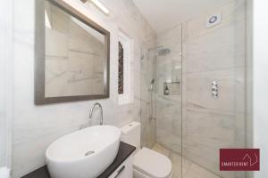 a bathroom with a white toilet and a shower at The Gazebo in London