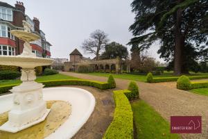 a fountain in the middle of a garden with a building at The Gazebo in London