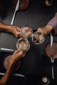 4 Personen, die Weingläser auf dem Tisch halten in der Unterkunft Hotel Rose Red in Brügge