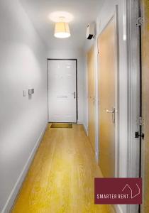 an empty hallway with a white door and a hard wood floor at Hitchin - Sharps Court in Hitchin