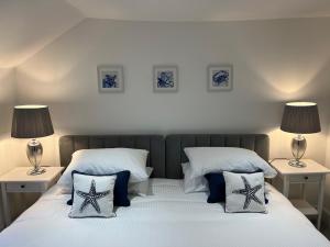 two beds in a bedroom with two lamps on them at The Sail Loft in Cowes