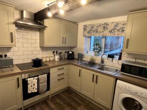 カウズにあるThe Sail Loft, Cowes High Streetの白いキャビネットとシンクのあるキッチン