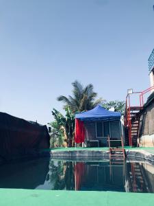 un barco con una tienda azul en el agua en Ingawale farmhouse (agro tourism) en Sātāra