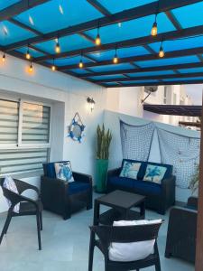 un patio con mesa, sillas y techos azules en Departamento Frente al Mar -MANTA, en Manta