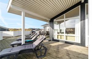 a row of lounge chairs on the deck of a house at Stunning Home In Hvide Sande With 4 Bedrooms, Sauna And Wifi in Bjerregård