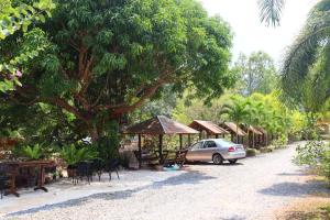 a car parked next to a street with trees and tables at Baanrimklong bungalow in Ko Chang