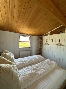 een slaapkamer met 2 bedden en een houten plafond bij Hestaland Horse Farm Cottage in Borgarnes