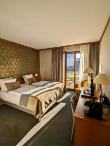 ein Hotelzimmer mit einem großen Bett und einem Schreibtisch in der Unterkunft James Vignoble Hôtel, Eguisheim in Eguisheim