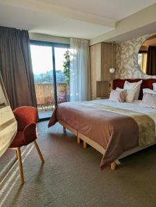Un dormitorio con una cama grande y una ventana grande en James Vignoble Hôtel, Eguisheim, en Eguisheim