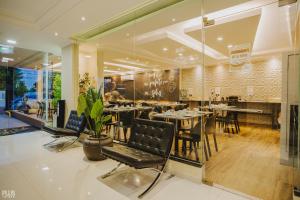 a restaurant with tables and chairs and a piano at Hotel Yvera Cataratas in Puerto Iguazú