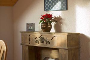 un vase au-dessus d'une table avec une fleur rouge dans l'établissement Ferienhaus am Mattenweg, à Hinterzarten