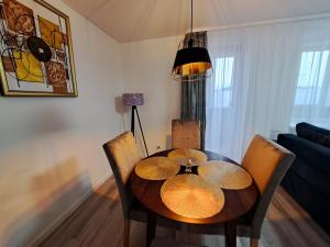 a dining room table and chairs in a living room at Jaukūs apartamentai centre A. J. Greimo g. in Šiauliai +9 photos