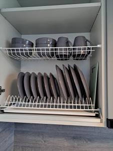 a shelf with plates and bowls on it at Jaukūs apartamentai centre A. J. Greimo g. in Šiauliai